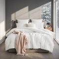 White box stitched comforter on a bed