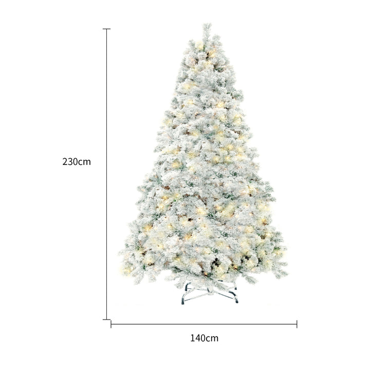 Snow-flocked white Christmas tree with warm-white lights