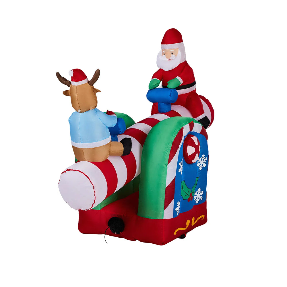 Inflatable Santa and reindeer seesaw lit at night