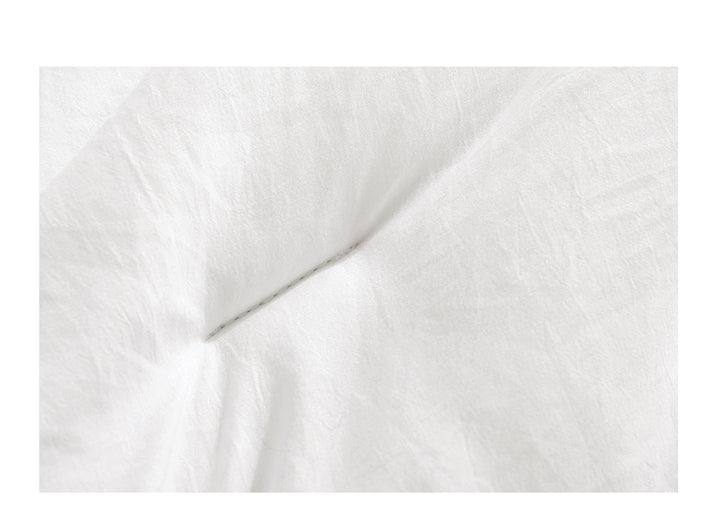 White box stitched comforter on a bed