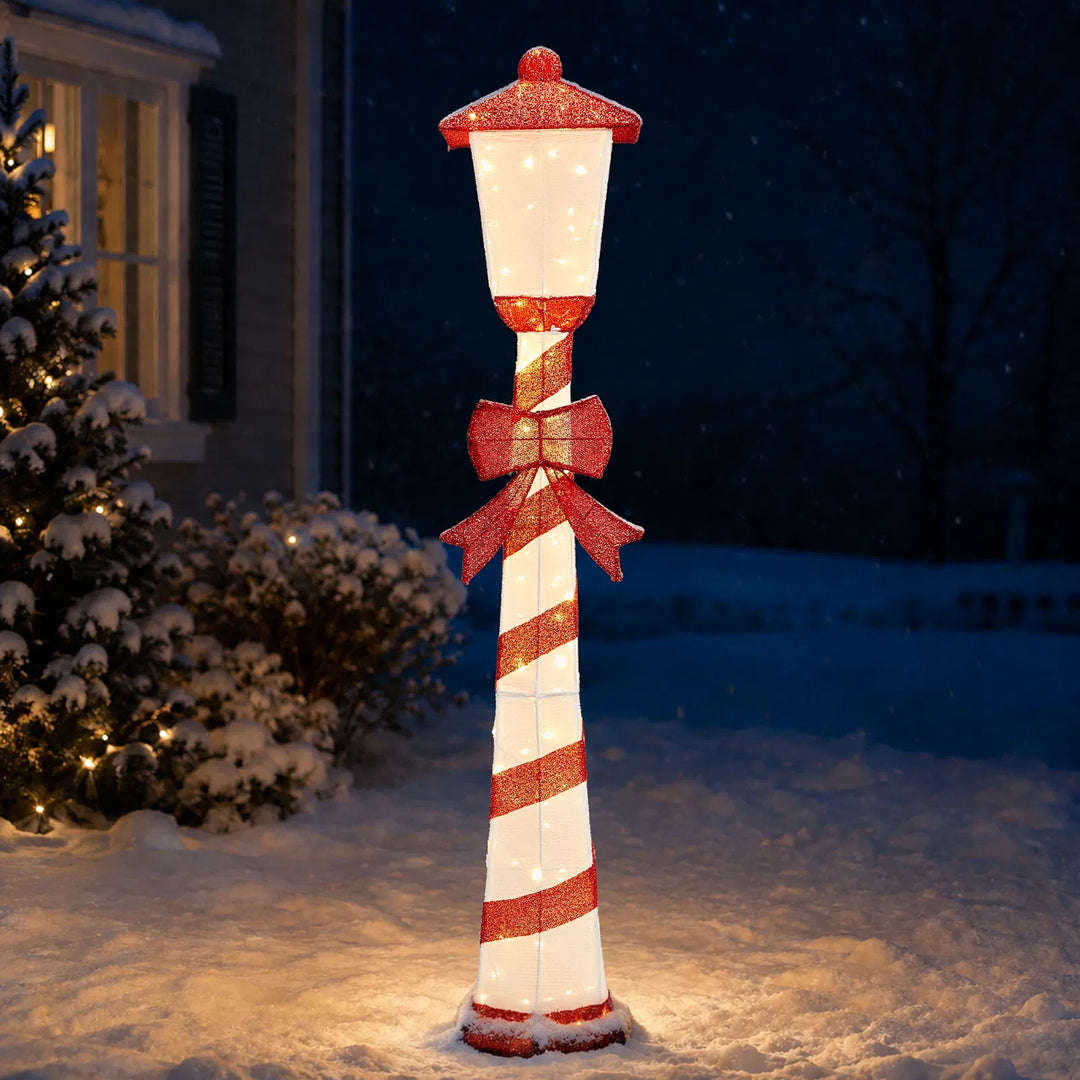 Lighted candy cane striped Christmas lamp post on a porch