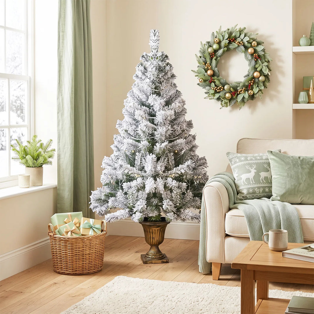 Small flocked Christmas tree in pot lit