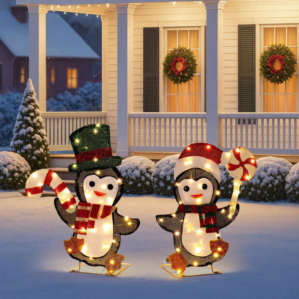Two lighted penguins with candy canes