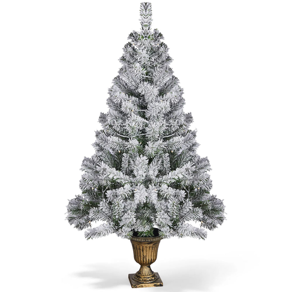 Small flocked Christmas tree in pot lit